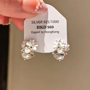 Detail view of silver flower earrings with large faceted cubic zirconia stones