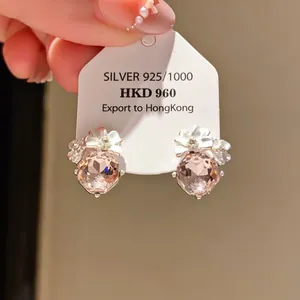 Detailed macro view of elegant crystal flower stud earrings with 925 silver export tag