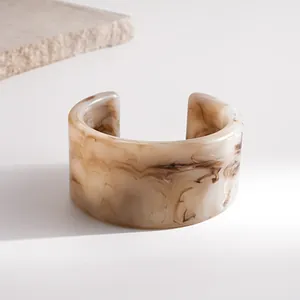 Close-up of retro marble texture resin open cuff bracelet in minimalist beige and brown