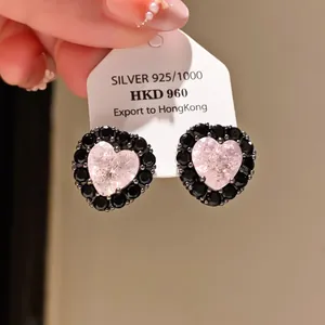 Close-up of heart-shaped earrings with pink center and black zircon border
