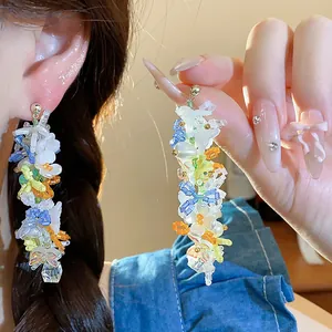 Orecchini pendenti colorati fatti a mano con fiori di vetro, farfalle e perle eleganti.