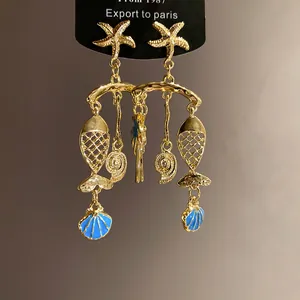 Detailed view of ocean-themed earrings featuring starfish fish and blue enamel shells