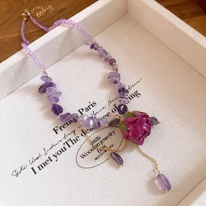 Macro detail of amethyst chip necklace featuring a realistic rose pendant in a gift box.