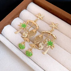 Detail view of tropical charms including starfish, fish, shell, and green palm tree.