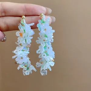 Dettaglio macro di orecchini floreali fatti a mano con farfalle e perline di vetro