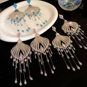 Close-up detail of vintage silver needle earrings with long glass teardrop tassels