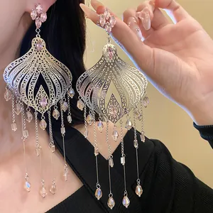 Close-up of ethnic retro silver needle earrings with pink glass teardrop tassels