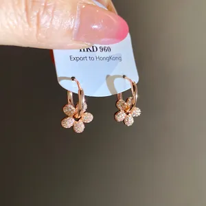 Gros plan détaillé des boucles d'oreilles fleur plaqué or 14k serties de zircons