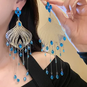 Elegant ethnic vintage chandelier earrings featuring blue glass waterdrop tassels on model