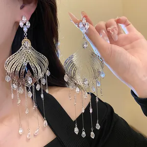 Detailed view of vintage filigree earrings with shimmering glass teardrop tassels.