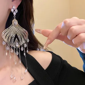 Detail of ethnic style tassel earrings with teardrop glass beads and silver needle.