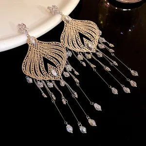 Detailed view of vintage gold-tone tassel earrings with clear glass water drop pendants