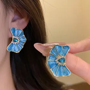 Pendientes de flor plisada en esmalte azul con diamantes de imitación estilo resort.