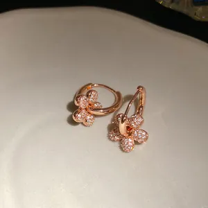 Vue détaillée de créoles plaquées or 14k avec pendentifs fleurs en zircone étincelants
