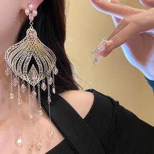 Close-up of ethnic style chandelier earrings with pink teardrop crystals and long tassels