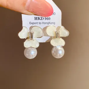 Close-up of elegant flower pearl earrings with glitter petals on a display tag