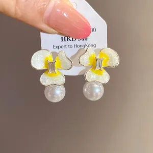 Close-up of elegant flower stud earrings with pearl drop and crystal center