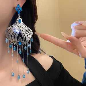 Macro detail of vintage ethnic style silver earrings with blue glass waterdrop tassels