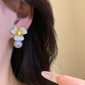 Detailed view of floral pearl stud earrings with sparkling silver needle design