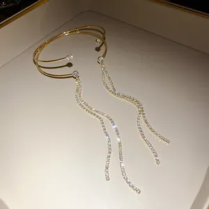Vista dettagliata di un elegante bracciale dorato a doppio strato con nappe di strass