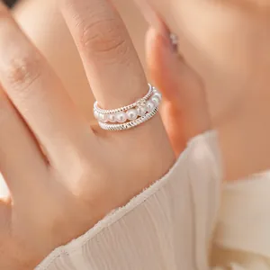 Exquisite close-up detail of a multi-layered silver ring featuring delicate white pearls