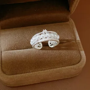 Close-up of elegant multi-layer silver ring with pearls and zircon details