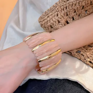 Dettaglio ravvicinato di un elegante bracciale in acrilico rosa con inserti oro