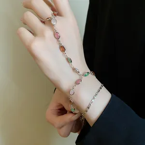 Dettaglio di una catena per mano vintage con pietre ovali in resina colorata e metallo.