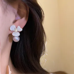 Detailed view of an elegant flower stud earring with pearl drop and crystal center