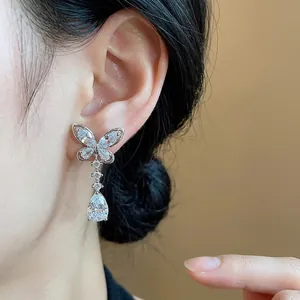 Elegante Schmetterlings-Ohrstecker in Silberoptik mit funkelnden Zirkonia am Ohr gezeigt