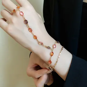 Dettaglio bracciale vintage a doppio strato dorato con pietre ovali in resina colorata.