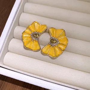 Exquisitos pendientes de flores plisadas en esmalte amarillo con detalles de strass