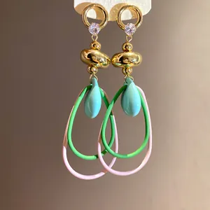 Gros plan de boucles d'oreilles rétro françaises avec perles colorées et zircons