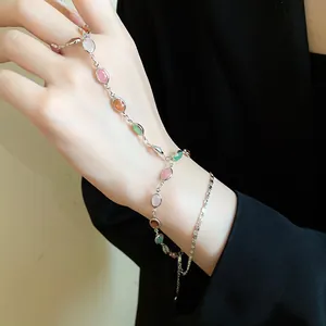 Dettaglio di un bracciale a mano vintage con ciondoli ovali in resina colorata su catena.