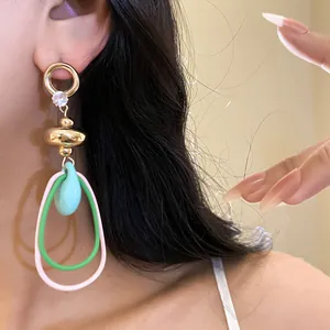 Vue détaillée de boucles d'oreilles pendantes vintage avec anneaux colorés et zircon