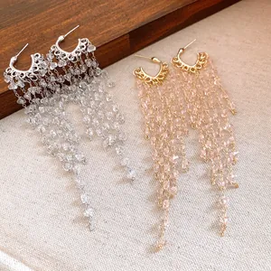 Macro detail of crystal tassel drop earrings with intricate gold and silver finish