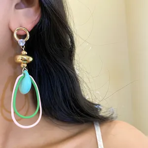 Gros plan de boucles d'oreilles vintage colorées avec zircon et anneaux