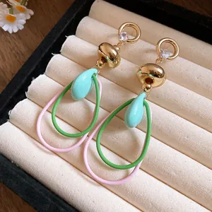 Gros plan de boucles d'oreilles pendantes rétro avec anneaux pastel et zircons fins