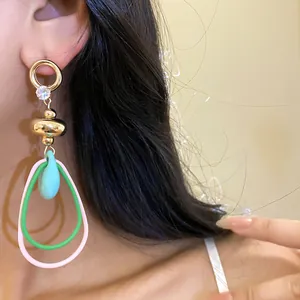 Gros plan de boucles d'oreilles rétro avec zircon et cerceaux colorés en forme de larme