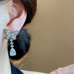 Nahaufnahme eines silbernen Schmetterlings-Ohrrings mit Zirkonia-Steinen am Ohr getragen.