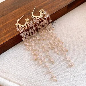 Exquisite close-up view of elegant light pink crystal tassel earrings with golden hardware details
