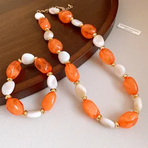 Close-up detail of the retro acrylic oval beaded necklace and bracelet jewelry set in orange