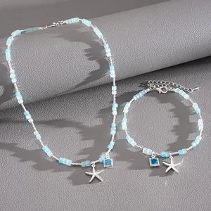 Détail exquis d'un ensemble de bijoux en perles de verre bleues avec breloques étoile de mer.