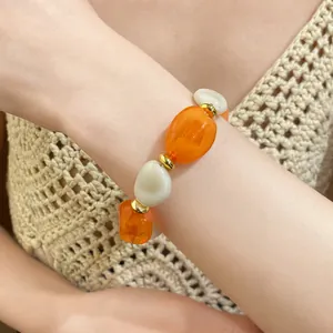 Close-up detail of retro acrylic oval beaded bracelet with orange and white beads
