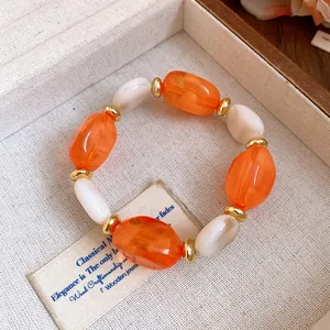 Detailed macro view of elegant acrylic oval beaded bracelet with golden rondelle spacers
