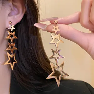 Close-up of gold-tone stainless steel star tassel earrings with four tiered stars