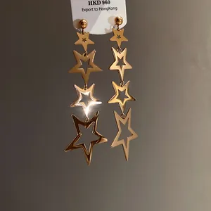 Close-up detail of stylish golden star tassel earrings featuring a hollowed-out star design