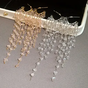 Close-up of silver needle crystal tassel drop earrings with sparkling diamond details