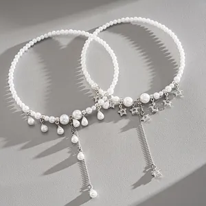Detailed view of white pearl chokers featuring star charms and elegant water drop tassels