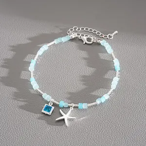 Vue détaillée d'un collier de perles argenté avec gemme bleue et pendentif étoile